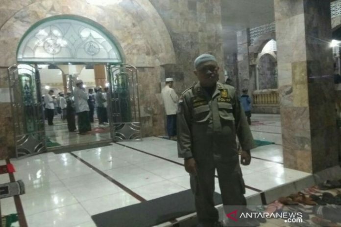 Petugas dari satgas penanganan COVID-19 mengawasi pelaksanaan Shalat Tarawih di Masjid Raya AtTaqwa Amuntai. (Antaranews Kalsel/Eddy Abdillah)