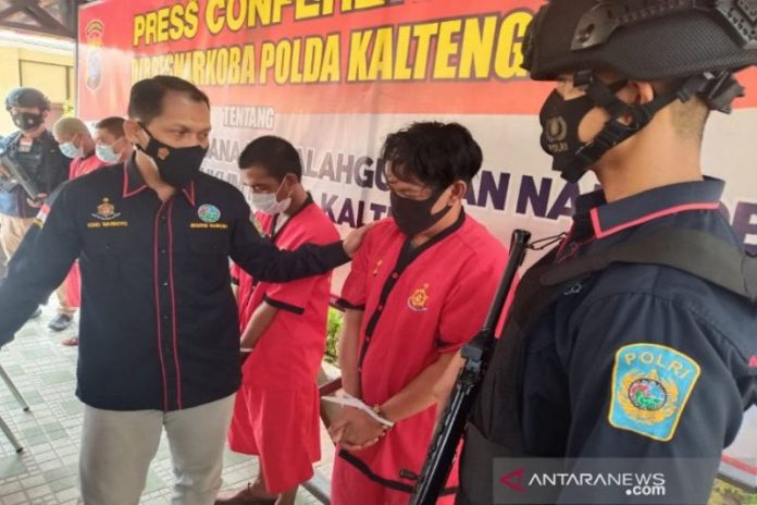 Direktur Reserse Narkoba Polda Kalteng Kombes Pol Nono Wardoyo berbincang dengan tersangka narkotika yang status ASN Kabupaten Pulang Pisau karena memiliki sabu seberat 147 gram lebih usai melaksanakan jumpa pers di Mapolda Kalteng di Palangka Raya, Kamis (15/4/2021). ANTARA/Adi Wibowo