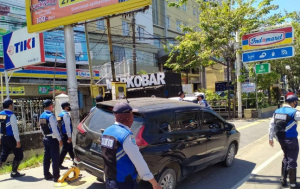Petugas Dishub Kota Banjarmasin menggembok ban sebuah mobil yang parkir di trotoar Jalan A Yani. (Dishub Banjarmasin)
