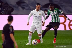 Penyerang Real Madrid, Eden Hazard (kiri) berusaha melepaskan diri dari kawalan bek Real Betis Emerson dalam pertandingan Liga Spanyol di Stadion Alfredo di Stefano, Madrid, Spanyol, Sabtu (24/4/2021) waktu setempat. (AFP/GABRIEL BOUYS)
