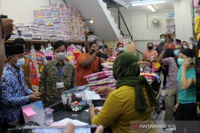 Wali Kota Surakarta Gibran Rakabuming Raka (dua dari kiri) didampingi Camat Pasar Kliwon Ari Dwi Daryanto (paling kiri) saat mengembalikan uang pungli dan meminta maaf kepada pemilik toko di Kelurahan Gajahan Pasar Kliwon Solo, Minggu (0205/2021) (ANTARA/Bambang Dwi Marwoto)