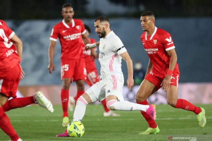 Penyerang Real Madrid, Karim Benzema (tengah) mengambil ancang-ancang sebelum menendang bola dalam pertandingan Liga Spanyol lawan Sevilla di Estadio Alfredo Di Stefano, Madrid, Spanyol pada 10 Mei 2021.(REUTERS/SUSANA VERA)