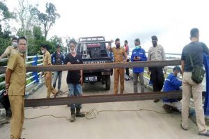 Kepala Dinas PUPR Barito Utara M Iman Topik didampingi Kepala Bidang Bina Marga Dedi dan personel Polsek Teweh Tengah serta pekerja las melakukan pengelasan besi di jalan pintu masuk ke jembatan, Senin (17/5/2021).ANTARA/HO-Dinas PUPR Barut