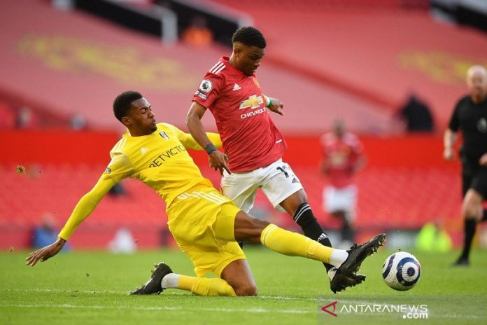 Bek Fulham Tosin Adarabioyo (kiri) berusaha merebut bola dari penguasaan talenta muda Manchester United Amad Diallo dalam lanjutan Liga Inggris di Stadion Old Trafford, Manchester, Inggris, Selasa (18/5/2021) waktu setempat. (ANTARA/REUTERS/POOL/Paul Ellis)