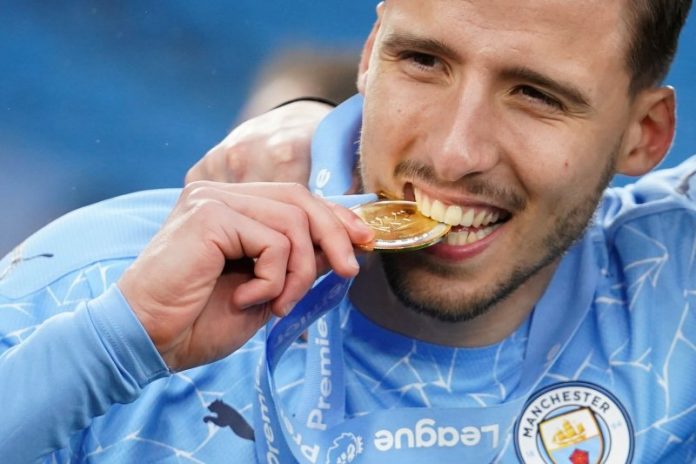 Foto arsip - Bek Manchester City Ruben Dias merayakan keberhasilan timnya menjuarai Liga Premier dengan menggigit medali juara pada 23 Mei 2021. (Pool via REUTERS/DAVE THOMPSON)