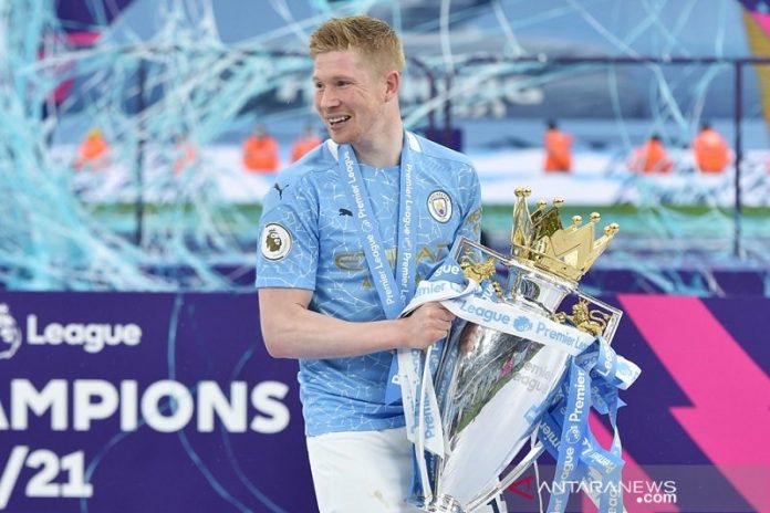 Gelandang serang Manchester City Kevin de Bruyne bersama trofi Liga Premier Inggris seusai seremoni penyerahan selepas laga pemungkas musim 2020/21 melawan Everton di Stadion Etihad, Manchester, Inggris, Minggu (23/5/2021). (ANTARA/REUTERS/POOL/Peter Powell)