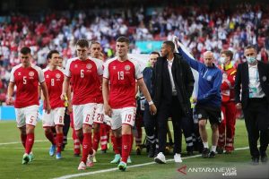 Para pemain tim nasional Denmark mengelilingi tim medis yang menandu rekan mereka Christian Eriksen meninggalkan lapangan setelah kolaps di tengah laga pembuka Grup B Euro 2020 melawan Finlandia di Stadion Parken, Kopenhagen, Denmark, Sabtu (11/6/2021). (ANTARA/REUTERS/POOL/Friedemann Vogel)