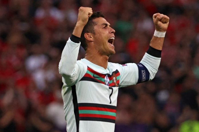 Pemain Portugal Cristiano Ronaldo yang menciptakan dua gol merayakan kemenangan timnya pada akhir pertandingan Portugal melawan Hungaria dalam Grup F UEFA EURO 2020 di Puskas Arena di Budapest pada 15 Juni 2021. (AFP/BERNADETT SZABO)