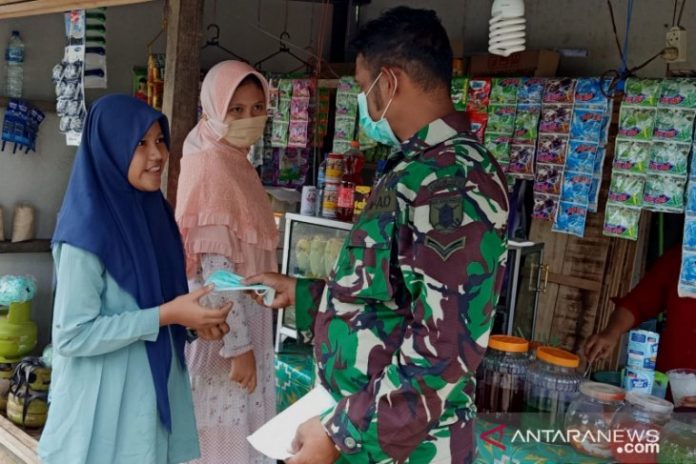 Personel TNI membagikan masker di wilayah TMMD ke-111 Tapin. (antara)