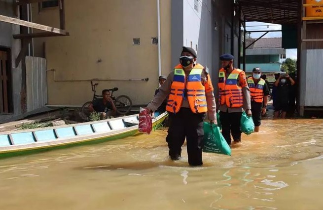 23082021_Personel Polda Kalteng menerobos air membagikan paket sembako untuk korban banjir Desa Tumbang Samba. (Istimewa-Humas Polda Kalteng)