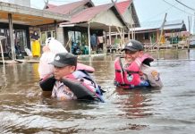 Dua Personel Polsek Dusun Hilir Terobos Banjir di Desa Mangkatir Barsel