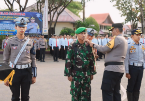 Kapolres Tanah Laut AKBP Muhammad Junaeddy Johnny SIK MH menyematkan pita kepada personel TNI. (wartabanjar.com - Ist. Humas Polres Tala)