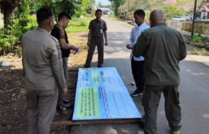 Anggota Satpol PP dan Damkar Tala memasang spanduk larangan membuang sampah di Jalan Basuki Rahmat, Pelaihari. (wartabanjar.com - Ist. Satpol PP Tala)