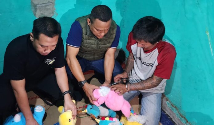 Di hadapan polisi, pelaku menggunting boneka mainan anak-anak tempat ia menyimpan sabu. (wartabanjar.com - Ist. Tribrata)