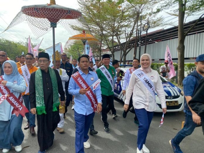 Yamin-Ananda berjalan kaki menuju kantor KPU Kota Banjarmasin untuk mendaftar Pilwali, Rabu 28 Agustus 2024. (wartabanjar.com - Iqnatius Aprianus)