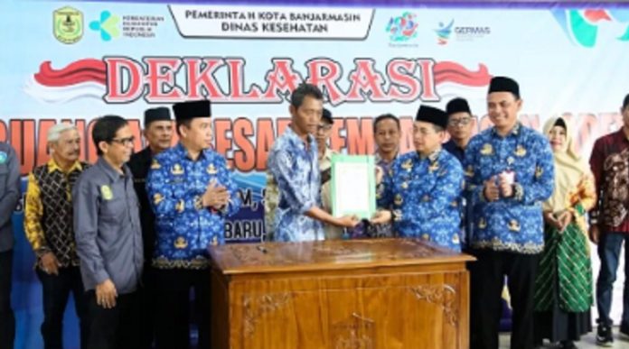 Wali Kota Ibnu Sina menyerahkan dokumen Deklarasi gerakan stop buang air besar sembarangan kepasa salah satu perwakilan warga. (wartabanjar.com - Ist. Dinkes Bjm)