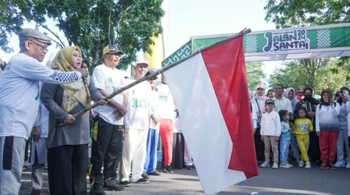 Acil Odah didampingi Ketua DPRD Kalsel H Supian HK (topi kuning hitam) mengibarkan bendera merah putih melepas peserta jalan santai. (wartabanjar.com - Ist. Humas Setwan)