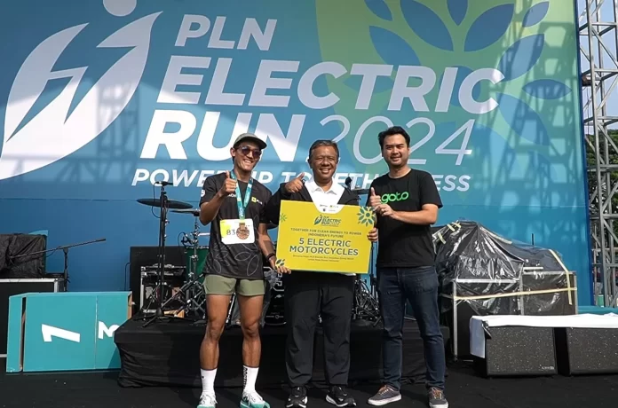 Direktur Legal & Manajemen Human Capital PLN Yusuf Didi Setiarto (tengah) ketika menyerahkan secara simbolis 5 unit motor listrik kepada perwakilan perusahaan Ojek Online dalam PLN Electric Run 2024. (DOK.PLN)