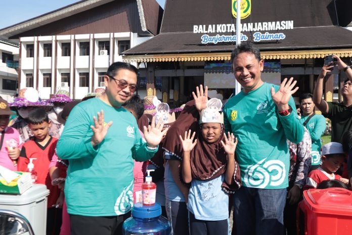 Wali Kota, Ibnu Sina dan Kepala Dinas Kesehatan Kota Banjarmasin, dr Tabiun Huda, di tengah anak-anak peserta lomba memeriahkan HKN 2024. (wartabanjar.com - Istimewa)