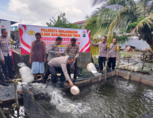 Jajaran Polsek Banjarmasin Timur dipimpin Wakapolsek menebar ribuan bibit ikan di kolam Jalan Ingup, Kuripan. (wartabanjar.com - Ist. Polsek Bjm Timur)