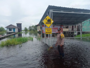 Anggota Polsek Sebangau, Kota Palangka Raya, memantau kondisi permukiman di Kameloh Baru yang terendam banjir akibat hujan. (wartabanjar.com - Ist. Humas Polresta Plk)