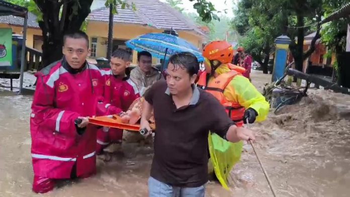 Tim evakuasi gabungan TNI, Polri, relawan bersama warga membawa seorang lansia melewati banjir di Sukabumi. (wartabanjar.com - Ist. Div. Humas Polri)