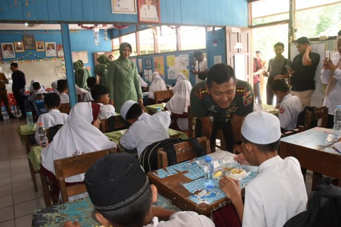 Dandim 1002 HST, Letkol Inf Fery Perbawa SHubInt MHan, menyapa murid yang tengah menikmati paket MBG. (wartabanjar.com - Ist. Pendim)