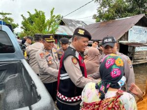 Kapolres Tanah Laut, AKBP Muhammad Junaeddy Johnny SIK MH, dan jajaran membagikan nasi bungkus kepada warga terdampak banjir di Bati-Bati. (wartabanjar.com - Ist. Humas)