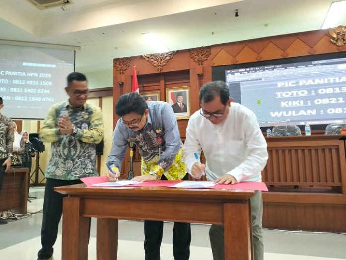 Ketua PWI Kalsel dan Kepala Diskominfo Kalsel menandatangani berita cara dana hibah untuk pelaksanaan HPN 2025. (wartabanjar.com - Ist. Humas PWI)