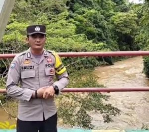 Bhabinkamtibmas Polres Banjar, Bripka Fauzi Ridwan, melakukan pemantauan kondisi debit air di Riam Kiwa Desa Paramasan Bawah, Kabupaten Banjar. (wartabanjar.com - Ist. Humas)