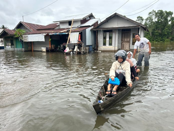 Kondisi banjir di Desa Sungai Tabuk Keramat, warga menggunakan jukung sebagai tranportasi. (wartabanjar.com - Iqnatius Aprianus)