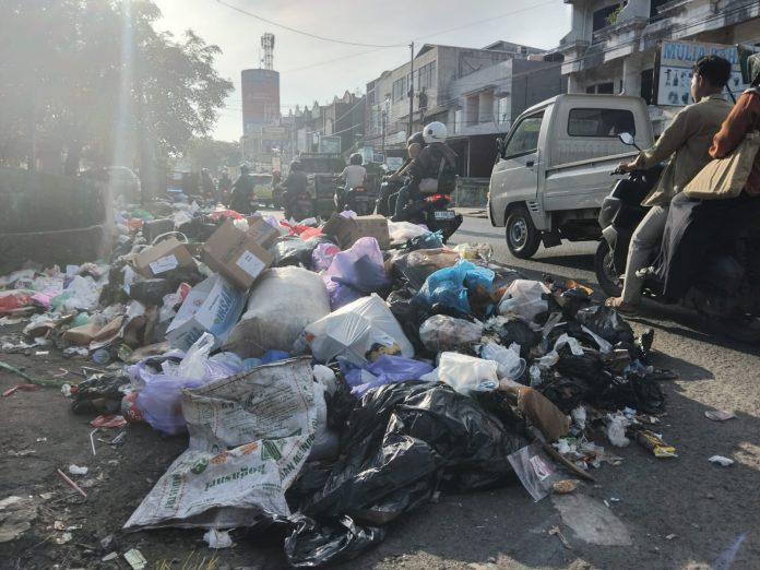 Tumpukan sampah di Jalan Soetoyo S, Teluk Dalam, meluber hingga ke jalan raya. (wartabanjar.com - Thania Ang)