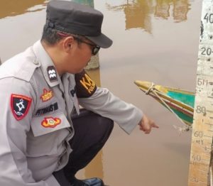 Personel Polsek Bukit Batu, Palangka Raya, memantau kondisi debit air Sungai Rungan, Senin. (wartabanjar.com - Ist. Humas)