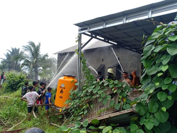 Tim Damkar gabungan Kota Banjarmasin melakukan pembahasan bangunan yang terbakar di Sungai Andai Jalan Kemiri 4, Kamis. (wartabanjarr.com - Riska Safitri)