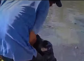 Dua pria mengangkat tubuh perempuan yang menceburkan diri ke sungai di Jalan A Yani Km 3 Banjarmasin, Senin siang. (wartabanjar.com - Ist. IG @info_banjarmasin)