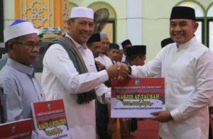 Bupati Tanah Laut, H Rahmat Trianto, menyerahkan secara simbolis dana hibah kepada perwakilan pengurus masjid di Batu Ampar, Selasa. (wartabanjar.com - Ist. MC Tala)
