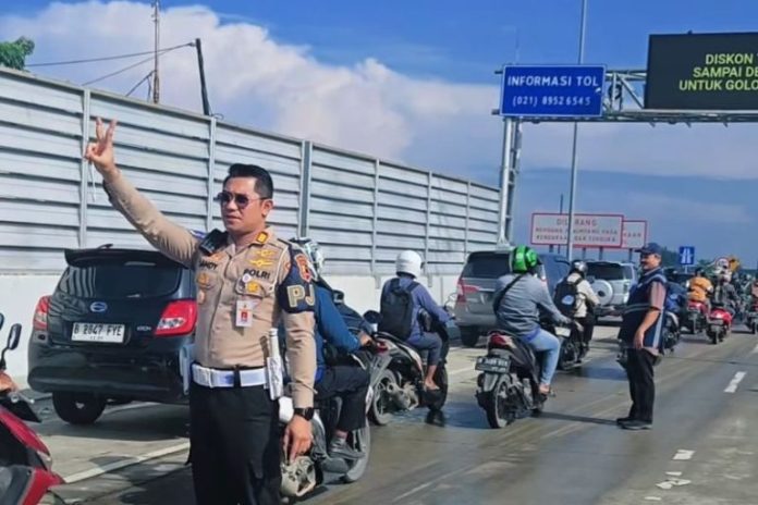 Anggpta polisi membuka jalan tol untuk pengendara motor akibat banjir yang mengepung Jabodetabek. (wartabanjar.com - Ist. Humas)