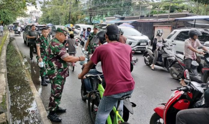 Jajaran Koramil Banjarmasin Timur dipimpin Danramil membagikan takjil kepada warga yang melintas di Jalan Veteran, Jumat. (wartabanjar.com - Ist. Pendim)