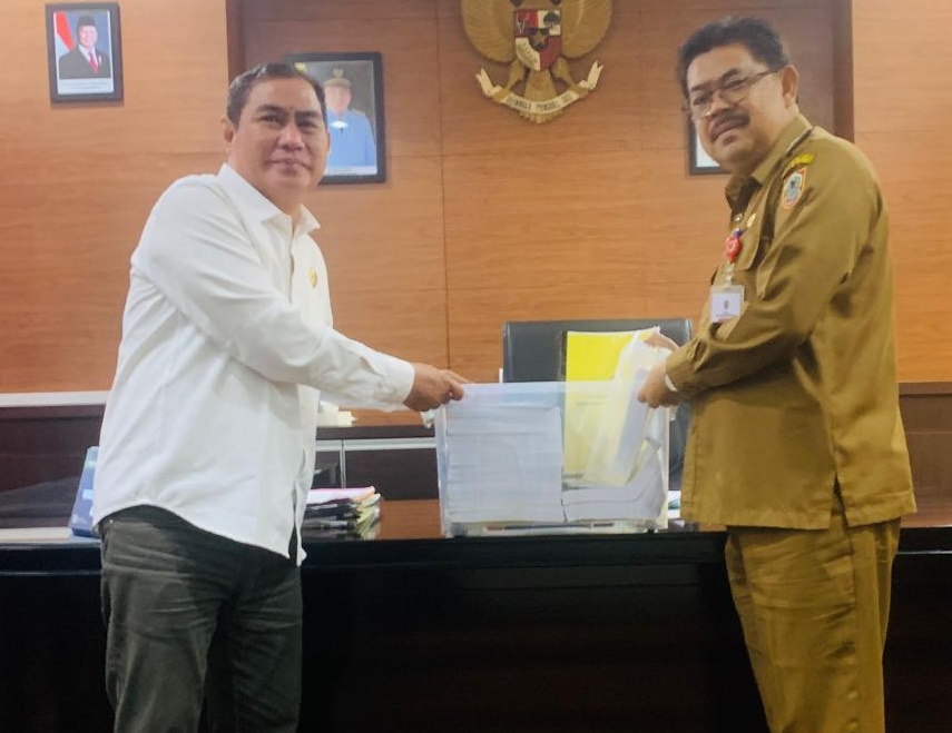 Ketua PWI Kalsel, Zainal Helmie, menyerahkan laporan penyelenggaraan HPN 2025 kepada Kadis Kominfo Kalsel, HM Muslim, Selasa. (wartabanjar.com - Ist. Humas PWI Kalsel)