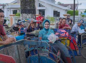 Ketua TP PKK Kabupaten HST, Deni Era Yulyantie yang akrab disapa Mama Deden, membagikan takjil kepada penarik becak di Barabai, Rabu. (wartabanjar.com - Ist. MC HST)