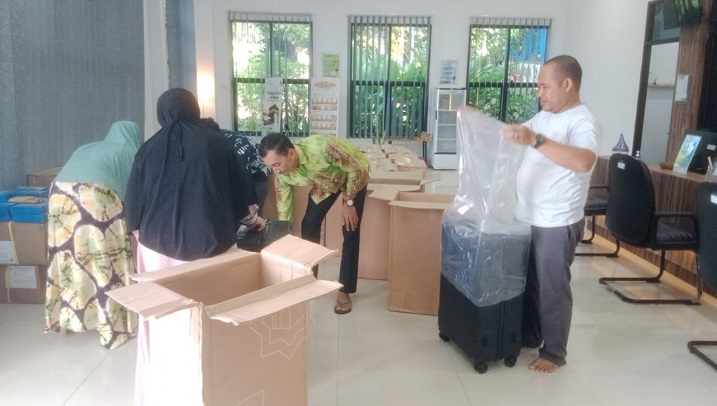 Kepala Seksi Penyelenggaraan Haji dan Umrah (PHU) Kemenag Balangan, Rahmadi, memeriksa koper yang akan dibagikan kepada jemaah, Kamis. (wartabanjar.com - Alfi)