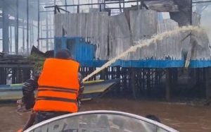 Personel Lanal Banjarmasin Pos Bahaur melakukan pemadaman kebakaran di pesisir Sungai Kahayan, Minggu. (wartabanjar.com - Ist. Lanal Banjarmasin)