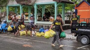 Relawan Banjarmasin Barat melakukan pembersihan sampah di 0 Km Banjarmasin, Minggu 20 April 2025. (wartabanjar.com - Ist @redbarmedia)