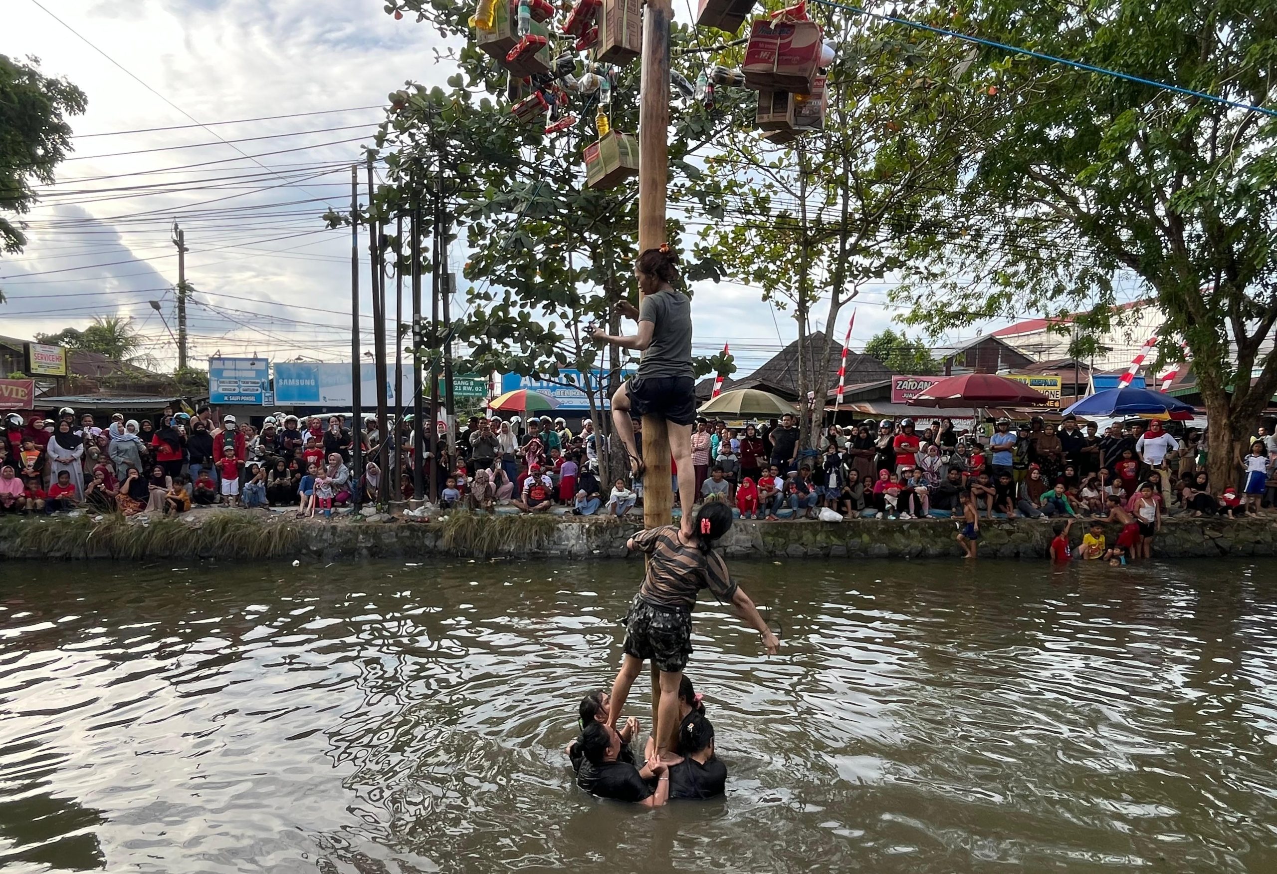 Lomba panjat pinang di sungai Veteran, kampung Batuah