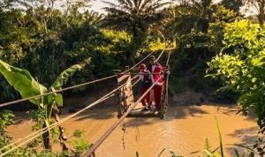 Dua murid SD diantar orang tua menyeberangi sungai penuh buaya