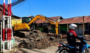 Ekskavator mengeruk tanah dan menancapkan batang galam di Jalan Veteran